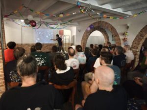 PassOut Goirle event: Speaker presenting on a projector screen to an audience. - Passing Zone