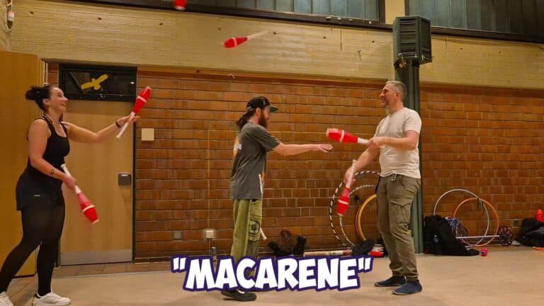 Three people juggling red clubs indoors, with "MACARENE" text overlay. - Passing Zone