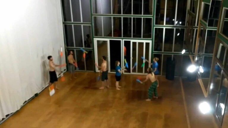 Group juggling clubs indoors, likely practicing for Tadah pickup event. - Passing Zone